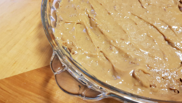 Caramel spread over biscuit base as layer of banoffee pie.